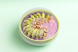 Acai bowl with blueberry smoothie, fresh kiwi, granola and poppy