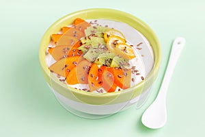 Acai bowl with vanilla smoothie, fresh persimmon, kiwi, kumquat