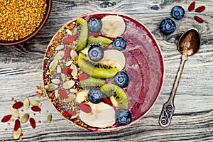 Acai breakfast superfoods smoothies bowl with chia seeds, bee pollen, goji berry toppings and fruits. Overhead. top view, flat lay