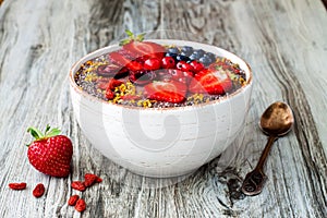 Acai breakfast superfoods smoothies bowl with chia seeds, bee pollen, goji berry toppings and peanut butter. Overhead