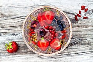 Acai breakfast superfoods smoothies bowl with chia seeds, bee pollen, goji berry toppings and peanut butter. Overhead