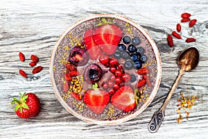 Acai breakfast superfoods smoothies bowl with chia seeds, bee pollen, goji berry toppings and peanut butter. Overhead