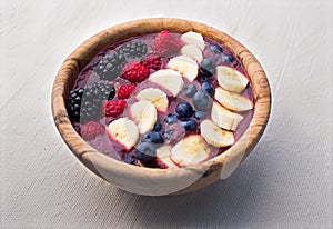 Acai cerry smoothie bowl with raspberries, bananas and blueberries