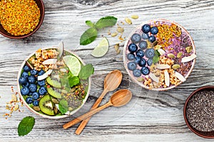 Acai and matcha green tea breakfast superfoods smoothies bowls topped with chia, flax and pumpkin seeds, bee pollen, granola photo