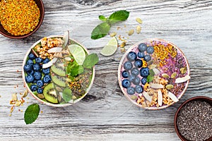 Acai and matcha green tea breakfast superfoods smoothies bowls topped with chia, flax and pumpkin seeds, bee pollen, granola