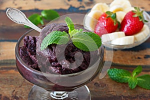 Acai pulp in glass with fresh mint, strawberry and banana