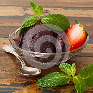 Acai pulp in glass with strawberry and fresh mint spoon