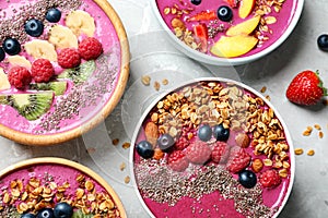 Acai smoothie bowls with granola and berries on table, flat lay