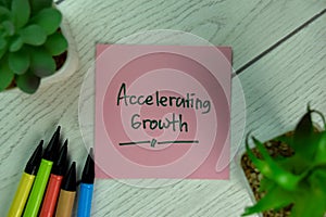 Accelerating Growth write on sticky notes isolated on Wooden Table
