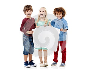 Accentuating copyspace with cuteness. Studio shot of a group of young friends holding up a blank placard together