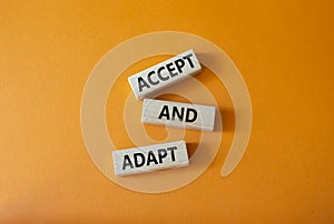 Accept or adapt symbol. Wooden blocks with words Accept and adapt. Beautiful orange background. Business and Accept and adapt