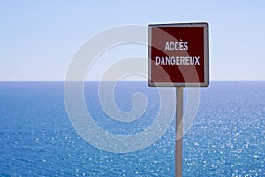 Acces dangereux text french panel sign means dangerous access on sea coast