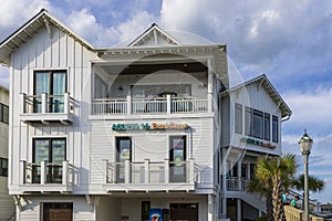 Access 16 Beach Shop at Johnnie Mercer's Fishing Pier with palm trees, people, light posts, blue sky and clouds