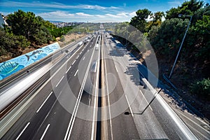 access road to the bridge and tolls of the 25 de Abril bridge seen from the city of Almada with motor vehicles in motion.