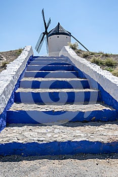 Access stairs to windmill in Consuegra, Toledo, Castilla La Mancha, Spain. Steps of intense blue lead to the entrance of the mill photo