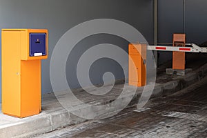 Entrance to chargeable parking space with turnpike and orange and charge machine