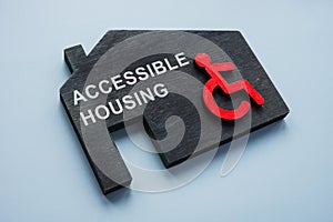 Accessible housing. Model of house and disabled person sign.