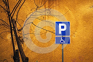 Accessible parking space sign against vibrant yellow wall