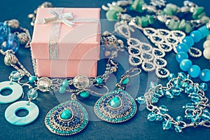 Accessories and decorations on a black background, gift box, earrings, bracelets, necklace close-up