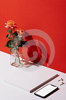 Smartphone and blank cover magazine mockup with accessories organised neatly on red and white background