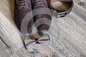 Accessories of the groom shoes, belt, cufflinks and a butterfly.