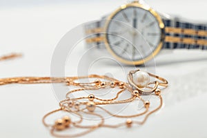 Accessories and jewelry for a fashionable girl : gold ring, necklace and original wristwatch