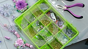 Accessories for needlework in container and tools for creating fashion jewelry.