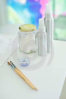 Accessories for pedicure brushes and gels with towels and a container in the background