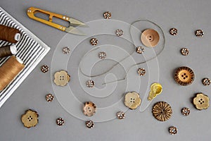 Accessories for sewing and needlework: buttons, scissors, needle with thread, set of reel of thread, textile, top view