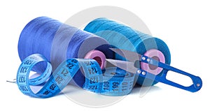 Accessories for sewing and needlework. Sewing centimeter and spools of thread on a white isolated background