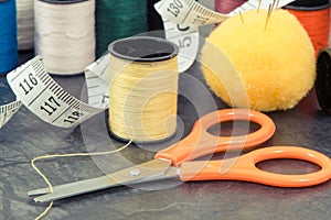 Accessories and tools for using in sewing. Spools of thread, needle, scissors and centimeter