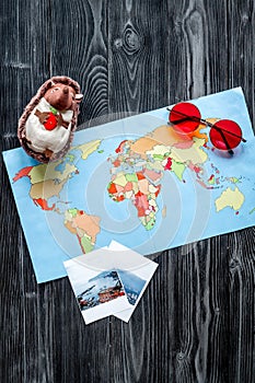 Accessories for treveling with children, map and photos on dark woode background top view