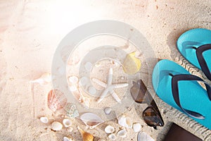 Accessories tropical with sunglasses, blue sandal, passport on the beach as background from seashell, starfish and sand on top vie