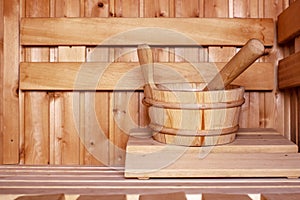 Accessories, a wooden bucket and a ladle, in a traditional Russian bath or Finnish sauna, in a cozy interior with natural