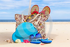 Accessory bag full sunbathers beach background