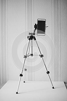 Accessory for the phone: a fully folded stand for a smartphone on the table against the background of the wallpaper, black and