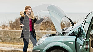 Blonde woman and broken down car on road