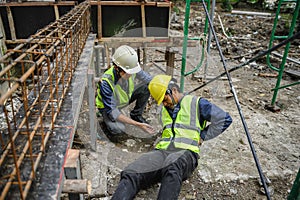 Accident of builder worker in work at construction site. Accident falls from the scaffolding on floor, Foreman support to help the