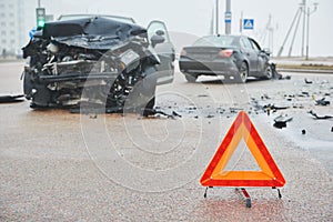 Accident or crash with two automobile. Road warning triangle sign in focus