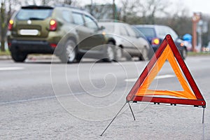 Accident or crash with two automobile. Road warning triangle sign in focus