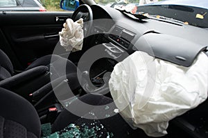 Accident damaged car with opened airbag