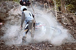 Accident in mountain bikes race in dirt track with flying debris during an acceleration