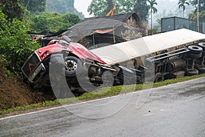 Accident on mountainous road, motor vehicle accident, car wreck. Long vehicle overturned and lying in ditch on side