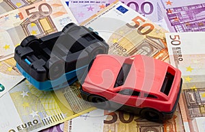 Accident of two cars isolated on a background of euro banknotes. Car crash concept