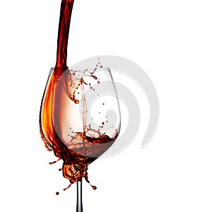 Accidental spill, stop action capture of red wine splashing on elegant glass isolated on white