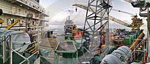 Accommodation work barge tied to oil platform during beautiful sunset