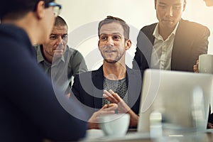 Accomplishing tasks at a faster pase as a team. a group of coworkers having a discussion in a boardroom. photo