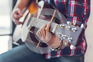 Accord chord, Close up of mens hands playing an acoustic guitar