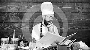 According to recipe. Man bearded chef cooking food. Guy read book recipes. Culinary arts concept. Man learn recipe. Try