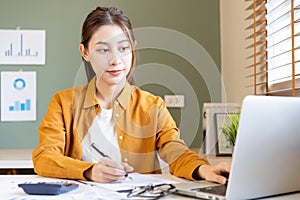 Accountant, attractive asian young woman sitting work from home, calculate tax income, expenses from data analysis for economy,